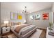 Modern bedroom featuring a stylish light fixture, comfortable bed, and bright natural light from a large window at 2331 E Delgado St, Phoenix, AZ 85022