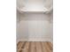 Walk-in closet featuring light hardwood floors, white walls, and white shelving with closet rods at 2331 E Delgado St, Phoenix, AZ 85022