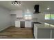 Modern kitchen featuring white cabinets, stainless steel appliances, and wood-look flooring at 2331 E Delgado St, Phoenix, AZ 85022