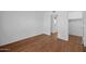 Bedroom with wood flooring, closet, and washer/dryer in separate area at 2625 E Indian School E Rd # 115, Phoenix, AZ 85016