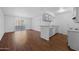 Open living space featuring wood floors and a kitchen with white cabinetry at 2625 E Indian School E Rd # 115, Phoenix, AZ 85016