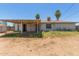 Exterior backyard of a single-story home with an outdated patio and mature palm trees at 3302 W Turney Ave, Phoenix, AZ 85017