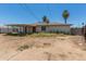 View of a single-story house with a rear-covered patio, visible yard, and block wall at 3302 W Turney Ave, Phoenix, AZ 85017