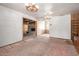 Living room featuring carpet, wood paneling, and two chandeliers at 3302 W Turney Ave, Phoenix, AZ 85017