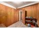A bedroom with wood paneling, carpet and open doorway to the bathroom at 4065 E University Dr # 141, Mesa, AZ 85205