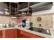 A kitchen featuring wood cabinets, a stainless sink, and an electric stove at 4065 E University Dr # 141, Mesa, AZ 85205