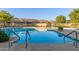 Inviting community pool showcasing comfortable seating, clear blue water, and lush landscaping, perfect for relaxation at 4202 E Broadway Rd # 130, Mesa, AZ 85206