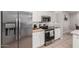 Contemporary kitchen featuring white cabinetry, a stainless steel refrigerator, and sleek appliances for a gourmet cooking experience at 4202 E Broadway Rd # 130, Mesa, AZ 85206