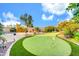 Expansive backyard featuring a well-maintained putting green, a built-in bar, and mature landscaping at 42318 W Abbey Rd, Maricopa, AZ 85138