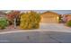 Charming home with a two-car garage, desert landscaping, and a beautiful flowering shrub next to the driveway at 42318 W Abbey Rd, Maricopa, AZ 85138