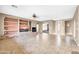 Large living room with fireplace, built-in shelving, tile flooring, and a sliding glass door at 42318 W Abbey Rd, Maricopa, AZ 85138