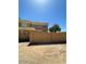 Beige two-story building featuring a secure perimeter wall and clear blue sky at 4236 S 46Th Pl, Phoenix, AZ 85040
