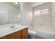Bright bathroom with a large mirror, a window over the tub, and a wood vanity at 4336 E Aspen Ave, Mesa, AZ 85201