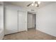 An empty room features a ceiling fan, tile flooring and a sliding door closet at 4336 E Aspen Ave, Mesa, AZ 85201