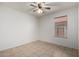 An empty room features a ceiling fan, tile flooring, and a single window at 4336 E Aspen Ave, Mesa, AZ 85201