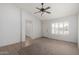Bright living room with a ceiling fan, tile/carpet flooring, and view of the front yard through the front door at 4336 E Aspen Ave, Mesa, AZ 85201