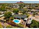 Aerial view showcasing a home with a backyard pool, patio, and a scenic mountain backdrop in a lush neighborhood at 5438 E Avalon Dr, Phoenix, AZ 85018