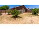Backyard featuring grass, small trees and bushes, partial fence, and sunny sky at 6515 W Hughes Dr, Phoenix, AZ 85043