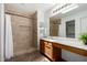 Bathroom featuring a tiled shower and vanity with ample counter space at 6515 W Hughes Dr, Phoenix, AZ 85043