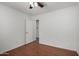 Bedroom featuring wood floors, neutral paint, ceiling fan, and an open doorway at 6515 W Hughes Dr, Phoenix, AZ 85043