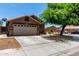 Inviting single-story home featuring a spacious driveway and neutral stucco exterior at 6515 W Hughes Dr, Phoenix, AZ 85043