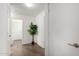 Hallway with neutral paint, tile flooring, potted tree, and multiple doorways at 6515 W Hughes Dr, Phoenix, AZ 85043