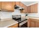 Kitchen with stainless steel stove top and hood, and wood finish cabinetry at 6515 W Hughes Dr, Phoenix, AZ 85043