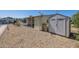 Exterior view of home with covered patio, matching storage shed, and low maintenance gravel yard at 6960 W Peoria Ave # 74, Peoria, AZ 85345
