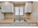 This cozy kitchen is equipped with a double stainless steel sink, cabinets, and a window at 6960 W Peoria Ave # 74, Peoria, AZ 85345