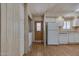 Bright kitchen with wood-look flooring, white cabinets, stainless sink, and a side door to a laundry area at 6960 W Peoria Ave # 74, Peoria, AZ 85345