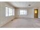 Inviting living room featuring neutral carpet, light walls, and ample natural light from the large windows at 6960 W Peoria Ave # 74, Peoria, AZ 85345