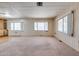 Bright living room offering neutral carpet, light walls, and large windows creating a welcoming atmosphere at 6960 W Peoria Ave # 74, Peoria, AZ 85345