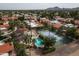 Aerial view of community pool, tennis courts, lush landscaping, and well-maintained homes at 8068 E Del Trigo Rd, Scottsdale, AZ 85258