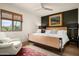Bright bedroom with a modern bed, accent wall, area rug, neutral-colored walls, and a window with natural light at 8068 E Del Trigo Rd, Scottsdale, AZ 85258