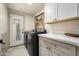 Bright laundry room features a washer, dryer, folding table, and white cabinets at 8068 E Del Trigo Rd, Scottsdale, AZ 85258