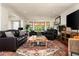 Spacious living room with ample seating, a ceiling fan, and abundant natural light, creating a welcoming space at 8068 E Del Trigo Rd, Scottsdale, AZ 85258