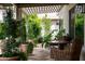 Covered patio with stone flooring, potted plants, a small table, and wicker chairs for outdoor relaxation at 8068 E Del Trigo Rd, Scottsdale, AZ 85258