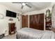 Cozy bedroom with dark wood closets, ceiling fan, carpet, and wall-mounted television at 8602 N 41St Ave, Phoenix, AZ 85051