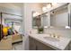 Ensuite bathroom featuring modern vanity with double mirrors, modern fixtures, and seamless entry to the bedroom at 10305 W Campana Dr, Sun City, AZ 85351
