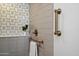 Close up of updated shower showing the modern fixtures, towel rack, and decorative tiles at 10305 W Campana Dr, Sun City, AZ 85351