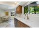 Bright kitchen featuring white quartz countertops, shaker cabinets, updated fixtures, and marble-patterned floors at 10305 W Campana Dr, Sun City, AZ 85351
