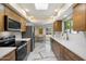 Modern kitchen with stainless steel appliances, wood cabinets, and stylish marble flooring at 10305 W Campana Dr, Sun City, AZ 85351