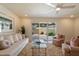 Cozy living room with neutral tones, plush carpeting, and a view to an enclosed patio at 10305 W Campana Dr, Sun City, AZ 85351