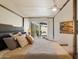 Primary bedroom with four-poster bed, ceiling fan, patio access, and stylish decor at 10305 W Campana Dr, Sun City, AZ 85351