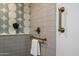 Modern shower featuring a golden shower head and a decorative geometric tile accent wall at 10305 W Campana Dr, Sun City, AZ 85351
