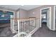 Hallway and staircase featuring neutral colors, white railing, and access to bedrooms at 10806 W Adam Ave, Peoria, AZ 85373