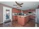 Eat-in kitchen featuring custom wood cabinetry, stainless steel appliances, and an island with counter seating at 10806 W Adam Ave, Peoria, AZ 85373