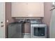 Laundry room with modern washer and dryer, overhead storage, and utility sink at 10806 W Adam Ave, Peoria, AZ 85373