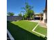 Wide shot of landscaped backyard with covered patio and artificial turf at 1352 W Spine Tree Ave, Queen Creek, AZ 85140
