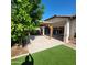 Landscaped backyard featuring covered patio and artificial turf at 1352 W Spine Tree Ave, Queen Creek, AZ 85140